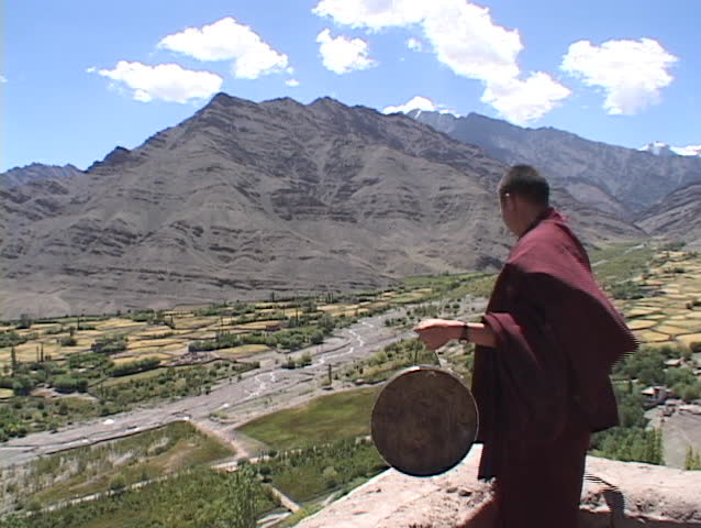 A Buddhist monk strikes a gong.
