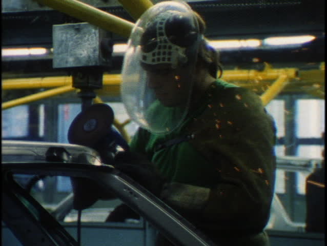 Workers work an assembly line in car factory.