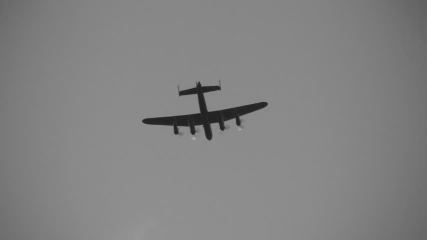 Avro Lancaster, a British bomber from World War 2 flies overhead. Black and white.