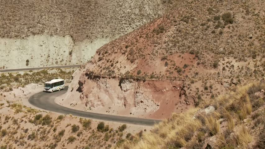 Car driving down desert road in the Andes
