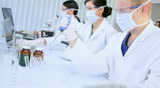 Three multi ethnic male and female medical researchers working with laboratory equipment