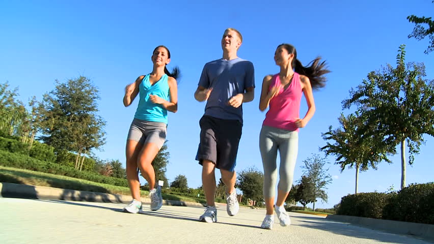 Young running partners keeping to a fitness program together jogging outdoors