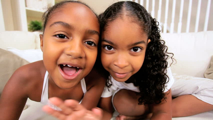 Little ethnic girls at home using online technology to video chat with family