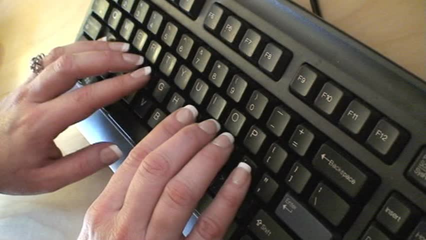Female with nice nails typing on a keyboard