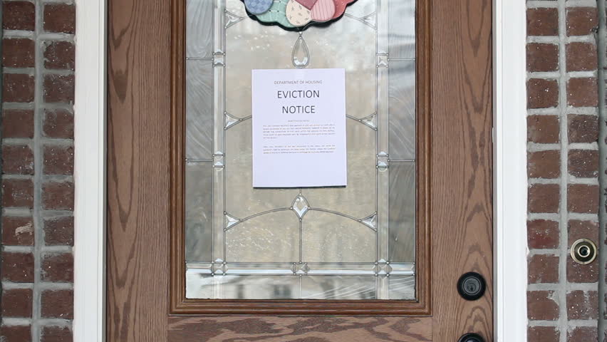 Eviction notice on front door of house as home owner returns.
