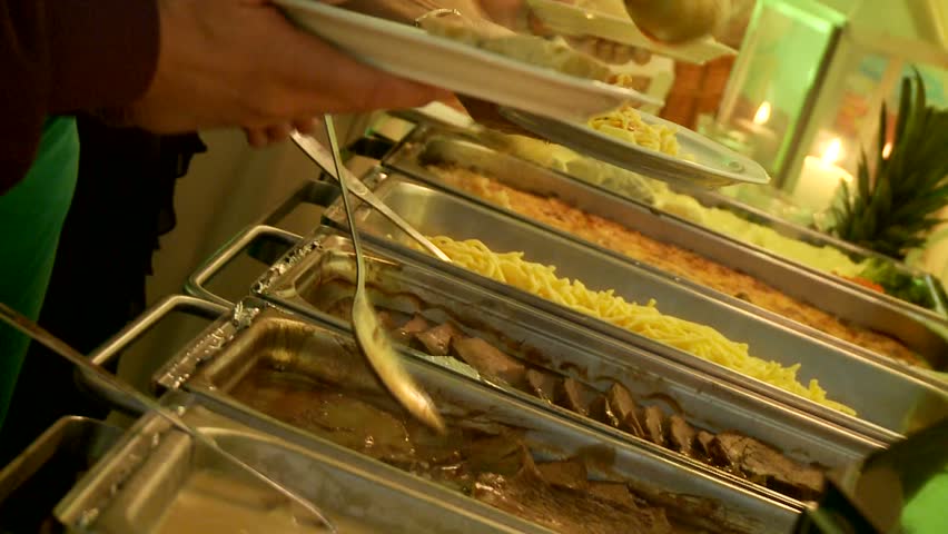 Restaurant guests select food from a buffet