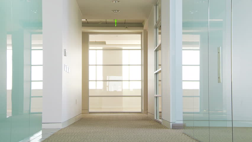 Two businesswomen dancing in office hallway giving a high five