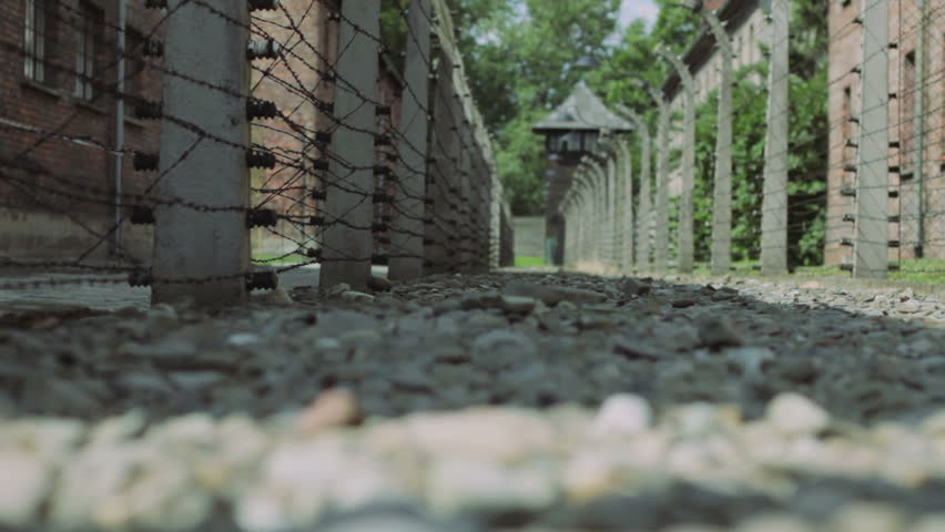 AUSCHWITZ, POLAND - CIRCA 2010: Walkway and barbed wire fence at Auschwitz concentration camp in Poland circa 2010. Dolly move left to right.