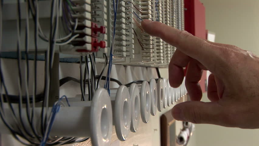 repairman checking voltages on a punch block