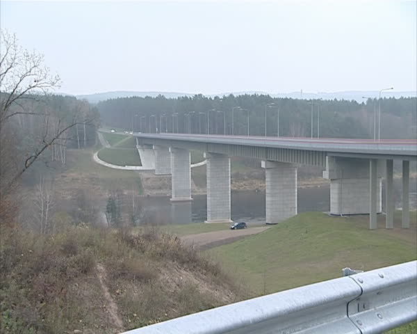 Large high bridge over river and cars ride it. Architectural decisions.
