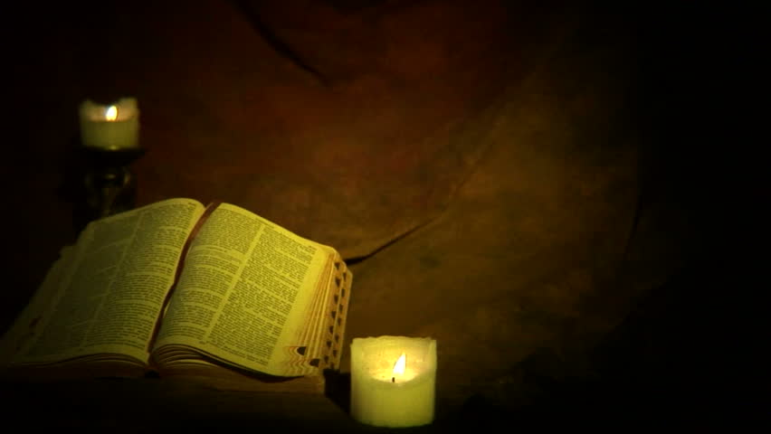 Dolly moves left to show old gothic bible with candles. Shot with DOF adapter, focus on bible