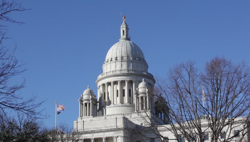 Providence Rhode Island State Capital building close up of the dome with American flags flying on clear day with blue sky. 1080 p HD 30 sec