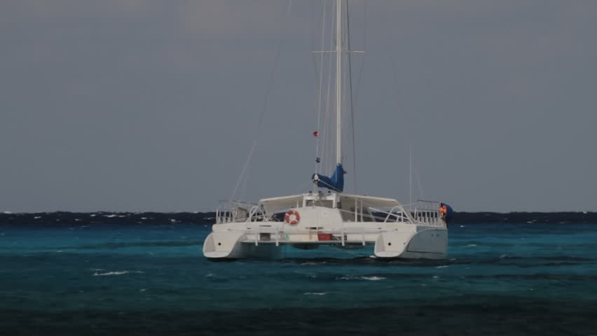 Catamaran in Caribbean Sea (HD). Catamaran boat used for transportation floating in the Caribbean sea. Every legend, number and name on the boat has been rotoscoped frame by frame to erase it. 