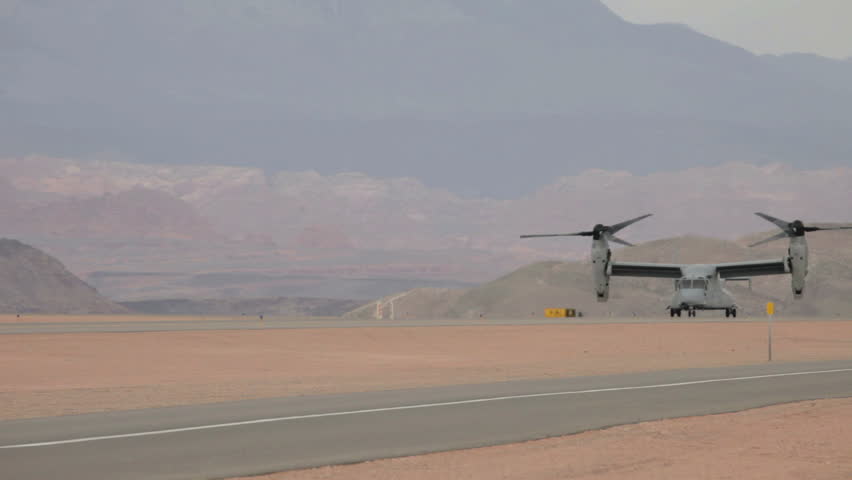 Aircraft V-22 Osprey VTOL hover mode taxi on runway during strong sand storm video in Utah. Used by USAF, Marines, Navy and NATO allies in Iraq, Afghanistan and worldwide.
