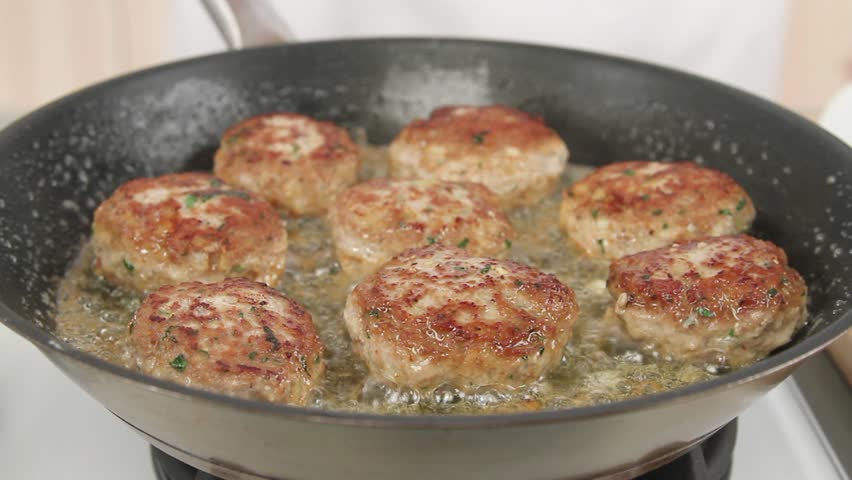 Butter being added to frying burgers