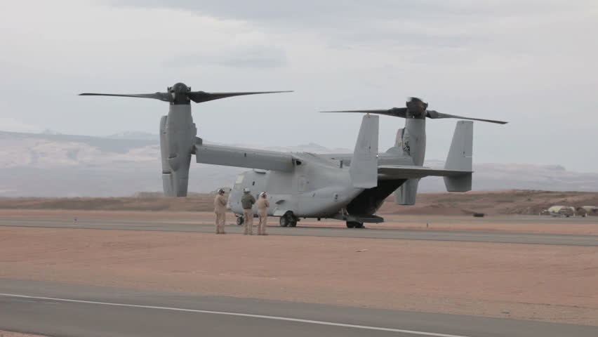 ST GEORGE, UTAH - MARCH 17: Aircraft V-22 Osprey VTOL hover mode on ground with crew members inspection before doing vertical takeoff and landing on March 17, 2012 in St. George, Utah. Used by USAF, Marines, Navy and NATO allies.