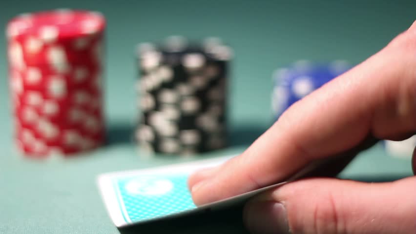 poker player looks his hand carefully