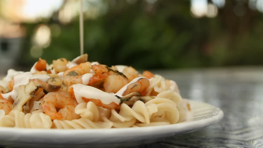 Fussily Shrimp Pasta With Cream (HD). Fussily pasta with shrimp and cream being applied on top. Slow panning to the left.