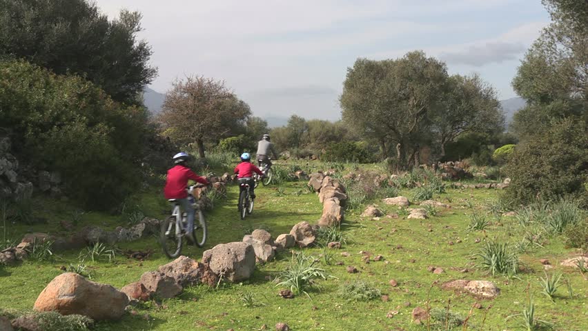 Sports activity, happy family of cyclists riding mountain bikes on countryside track. 