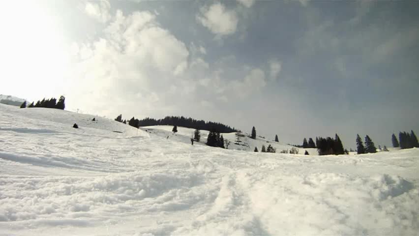 Skier skiing down the slope and stopping in the front of the camera