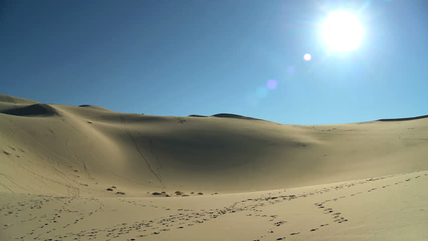 Gold sand desert dunes with sun shining