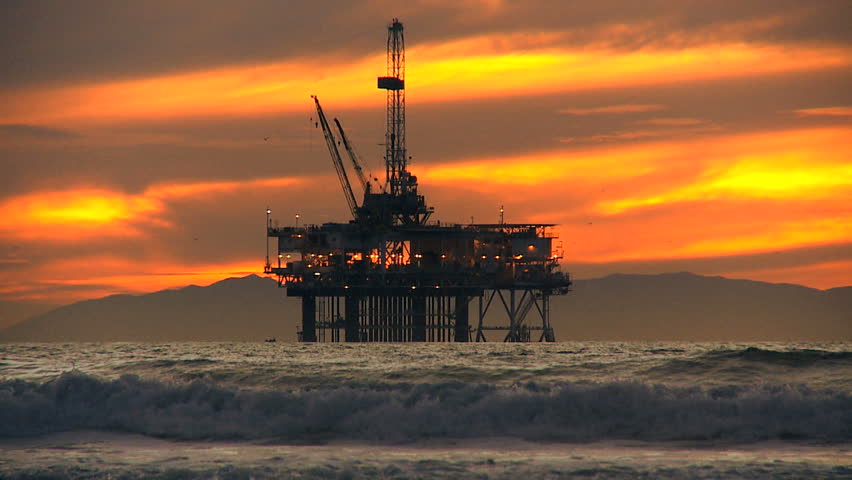 Fossil fuel pumping industrial oil rig at dusk