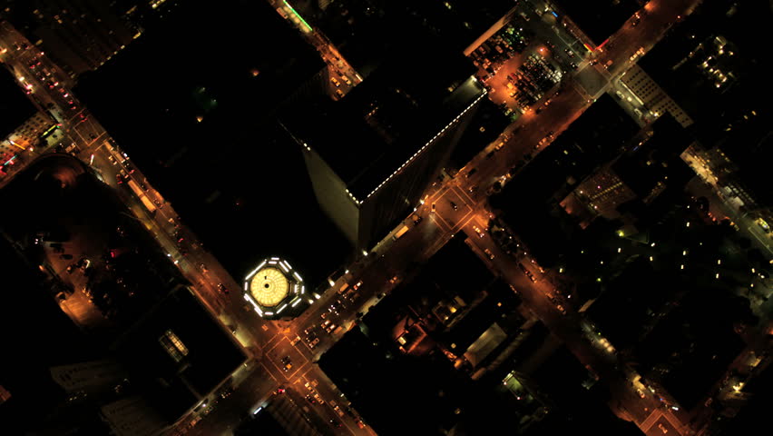 Aerial night vertical rooftop view of city traffic illuminated by city streets and skyscrapers, North America, USA
