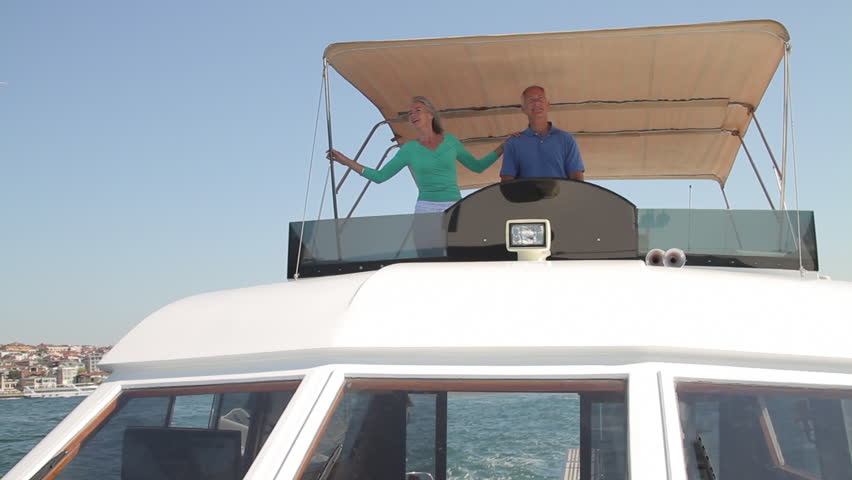 Senior male captain and female on nautical vessel