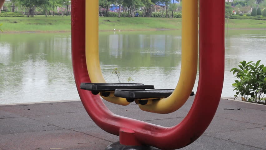 A young man begins working out on the exercise equipment at a local park.