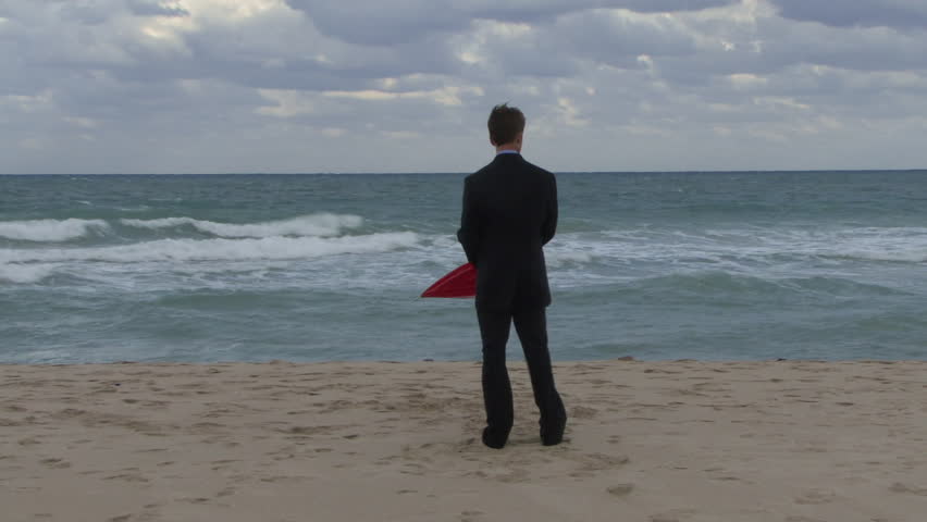 Male opening an umbrella on a beach