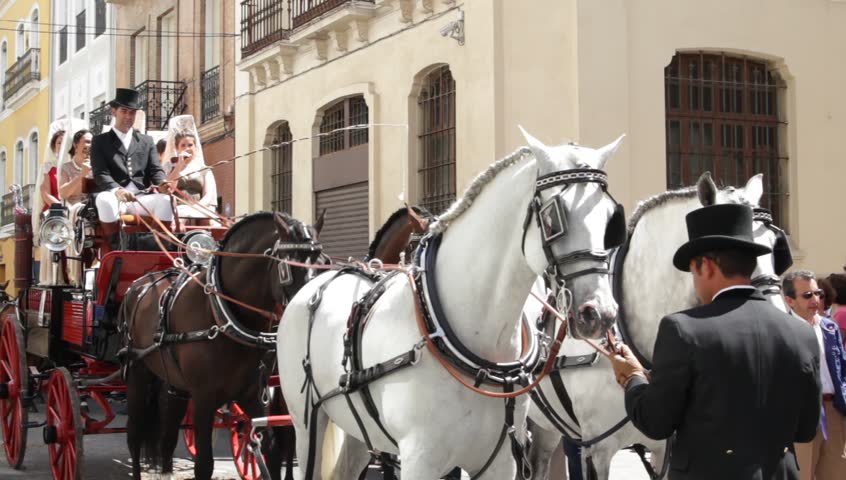 SEVILLE - APRIL 22: Traditional carriage parade the day before begins the world famous April's Fair of Seville on April 22, 2012 in Seville, Spain. Women and men wear traditional clothing.