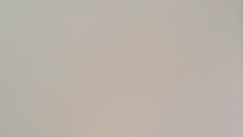 CLOSE UP PAN OF A NUDE YOUNG WOMAN MOISTURIZING ON WHITE BACKGROUND