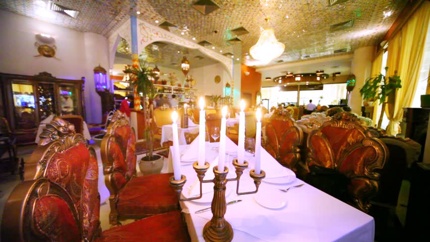 Lounge of restaurant is located behind candlestick with burning candles