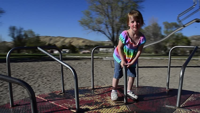 HD Video of little girl spinning on merry go round in park