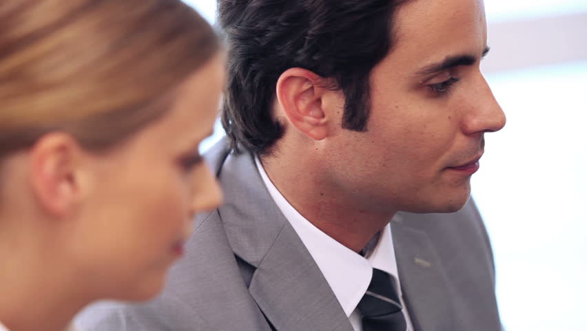 Businesswoman telling a secret to her colleague in a bright office
