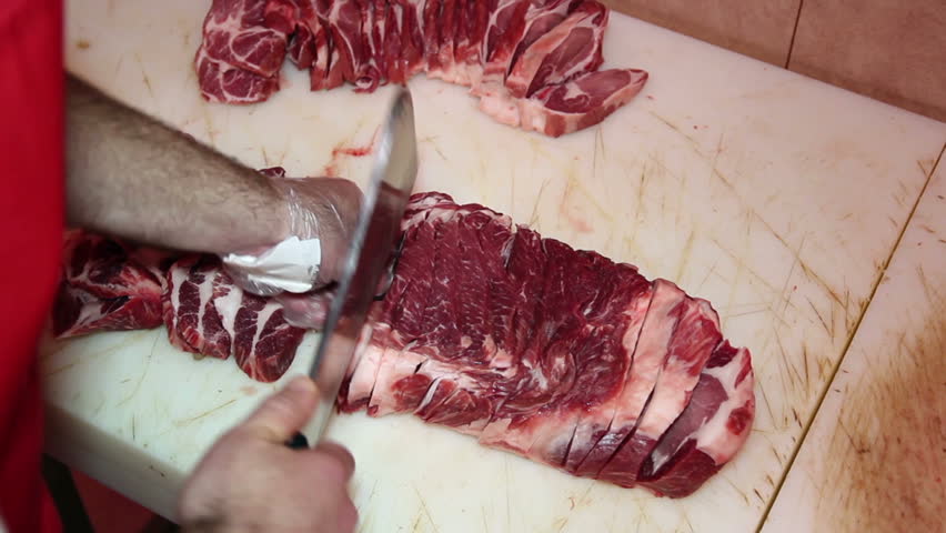 Butcher cutting meat.
Butcher man hand cutting raw meat with meat chopper. HD1080p. 