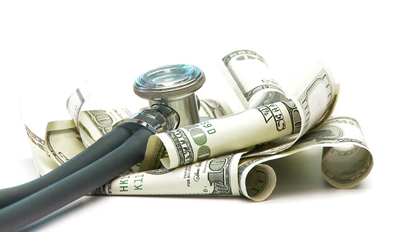 Close up of stethoscope on a pile of 100 dollar bills