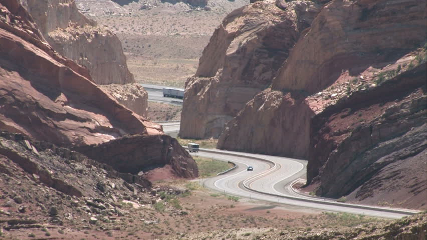 Zoom out Spotted Wolf Canyon I-70 inter state freeway southern Utah. Steep rugged cut through the San Rafael Swell. Highway turns. High desert scenery along scenic overlooks one of America's Byways.