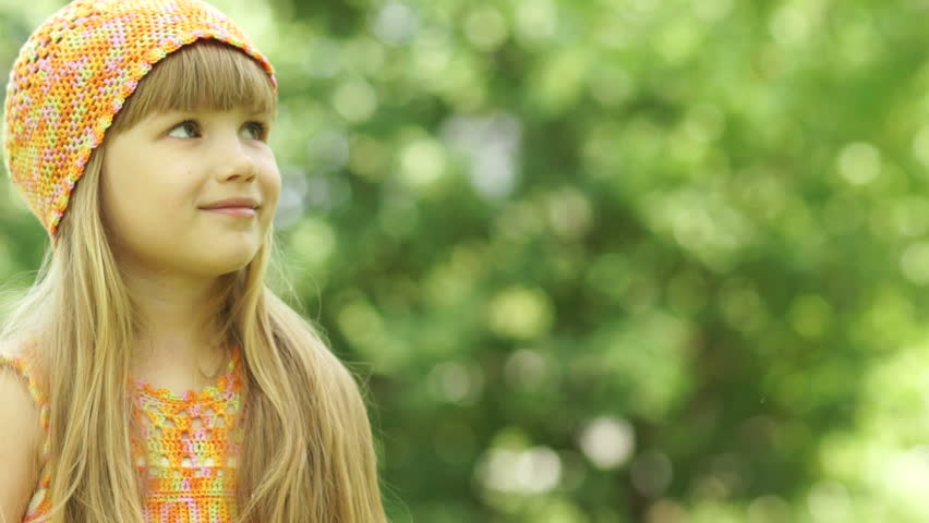 3s girl blowing a dandelion. Close-up portrait.