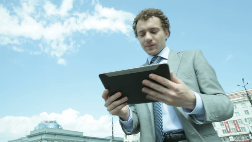 Businessman using a digital pad in urban environment, stabilized shot