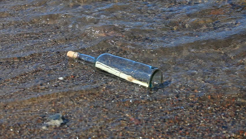 Message in a bottle in the water at the beach on the Baltic coast
