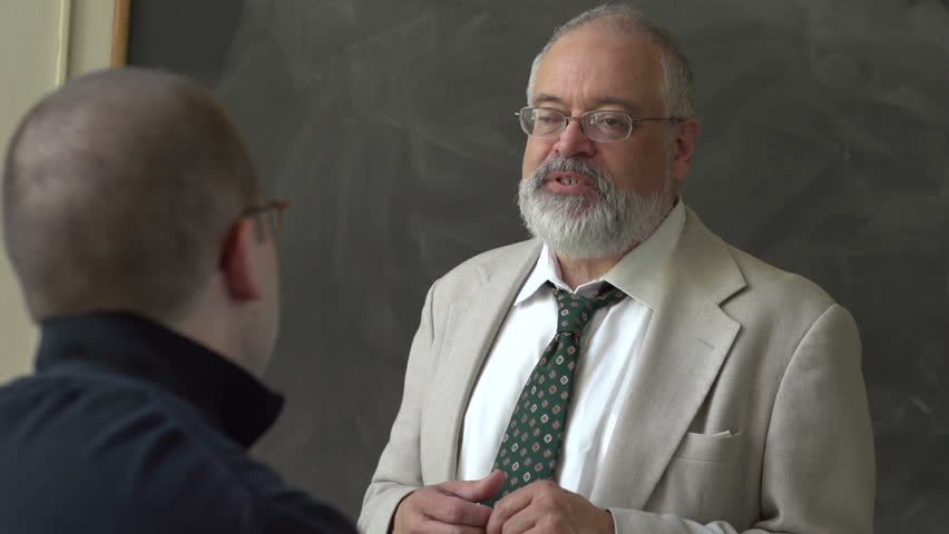 Professor and student talking in a classroom