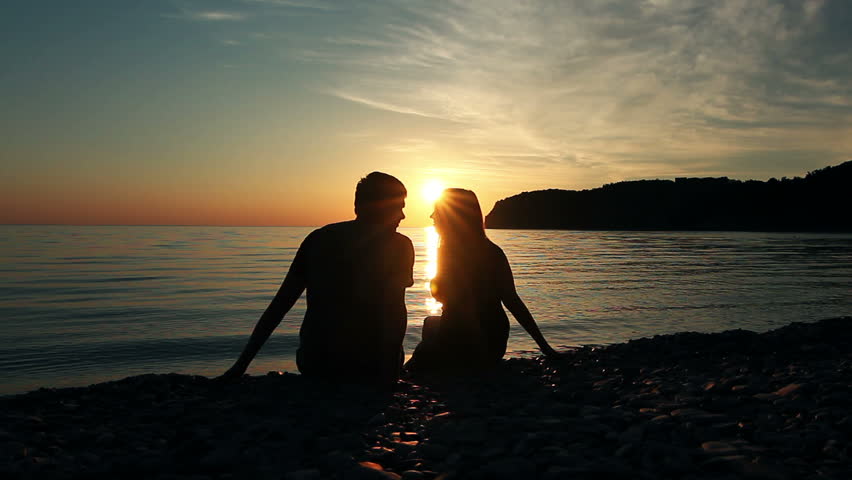 Couple on the shore of the sea, Romantic Couple at Sunset. Two people in love at sunset. Man and woman on the beach