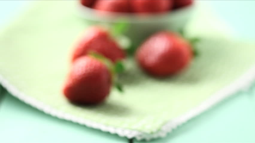 moving camera into bowl of fresh strawberries, tracking shot
