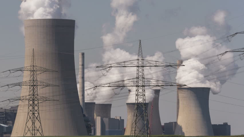Brown coal power plant with huge cooling towers and steam