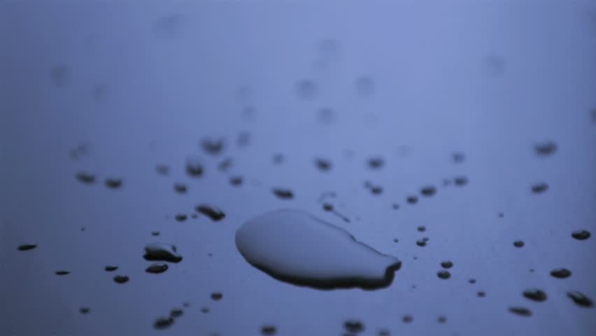 Drop splashing in super slow motion on a blue surface