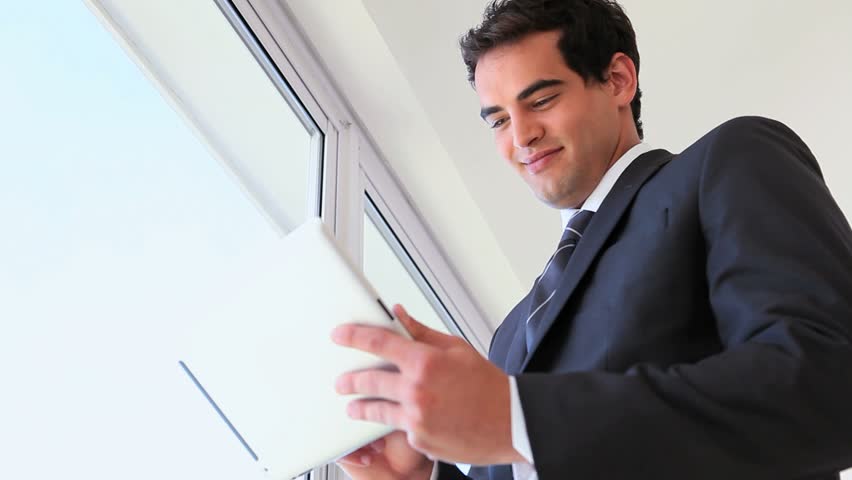 Man in suit using a touchpad near a window