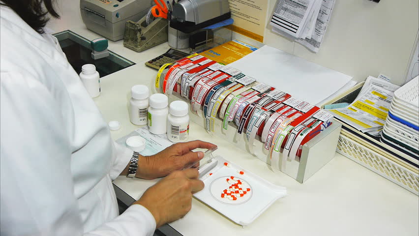 a pharmacist counts pills to fill a prescription