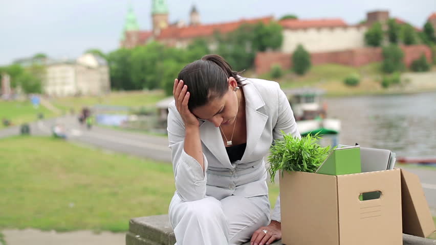 Just fired, unemployed sad young businesswoman sitting in the city

