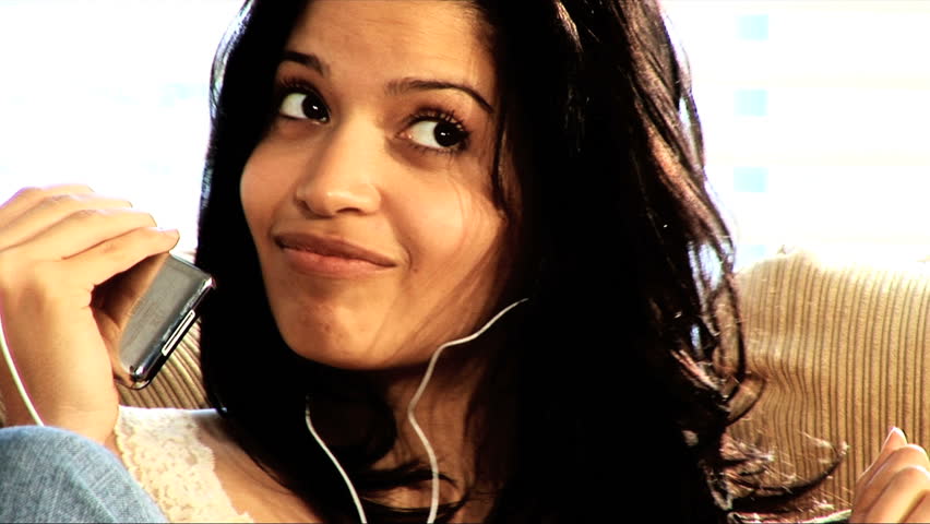 Beautiful latino girl relaxes at home with her mp3 player